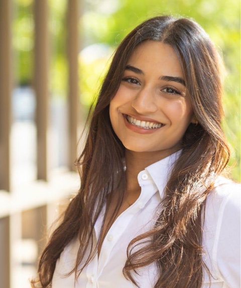 Dr. Tojjar in white button-down shirt, smiling headshot with natural light